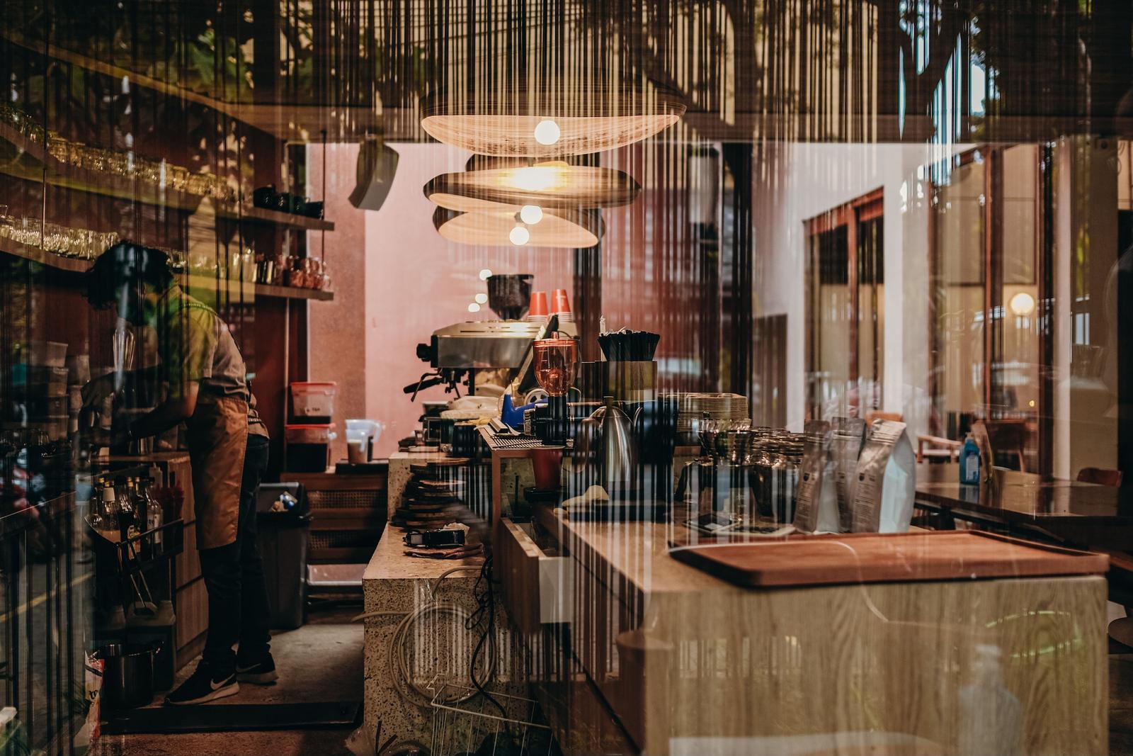 Neighbourhood cafe interior with a barista at the counter Neighbourhood cafe interior with a barista at the counter